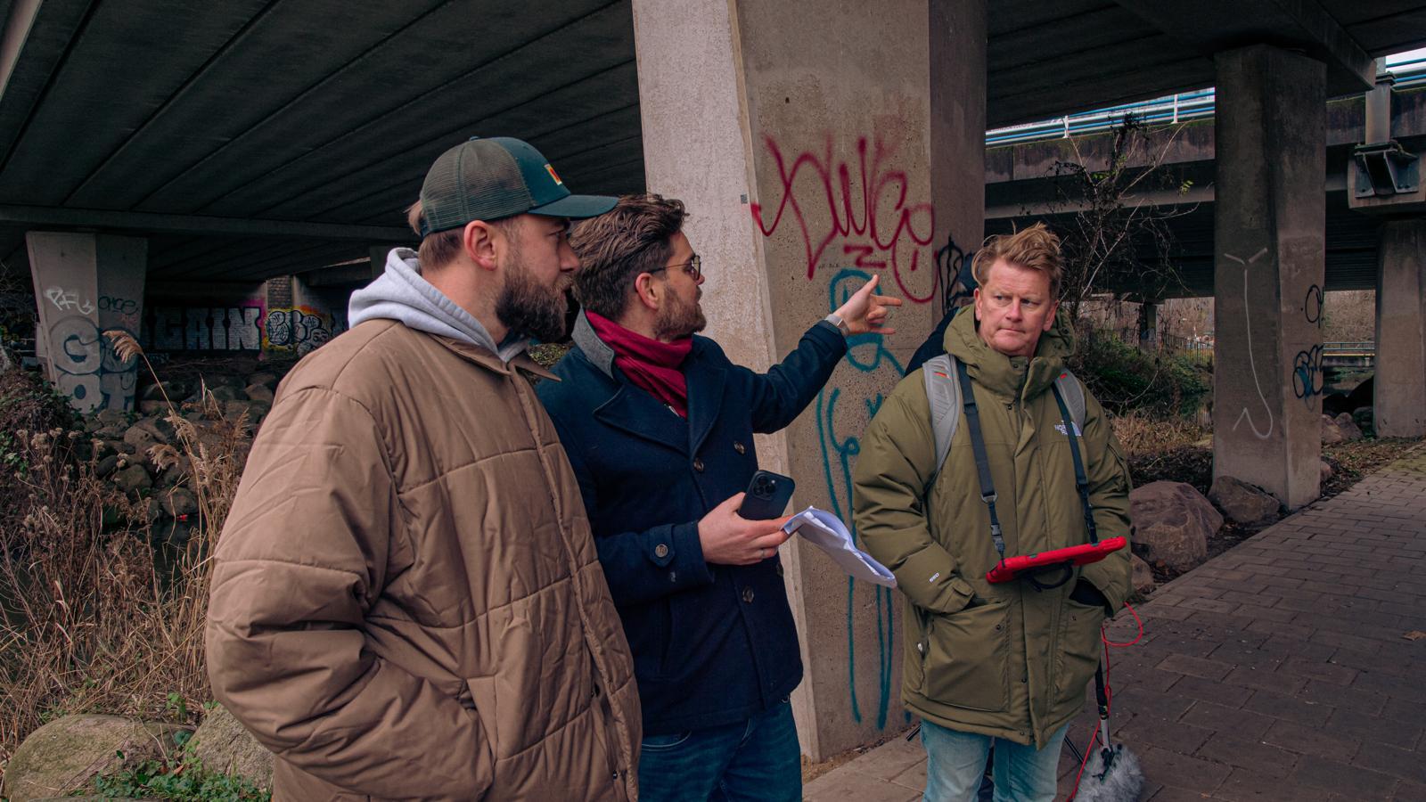 Morgan Grunefeld discussing a scene with actors under a flyover